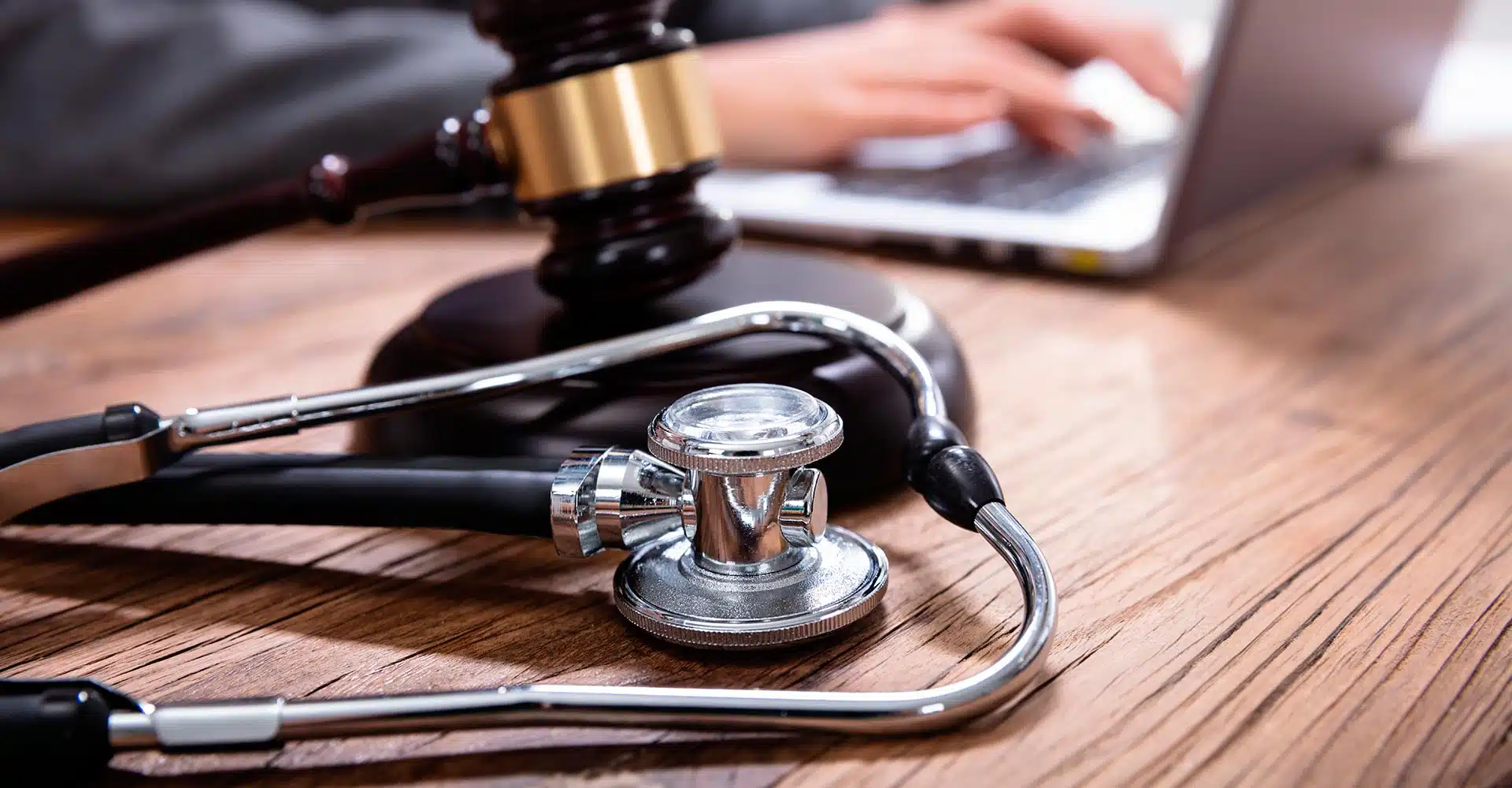 a stethoscope and judge gavel on a desk of an attorney working on a malpractice case